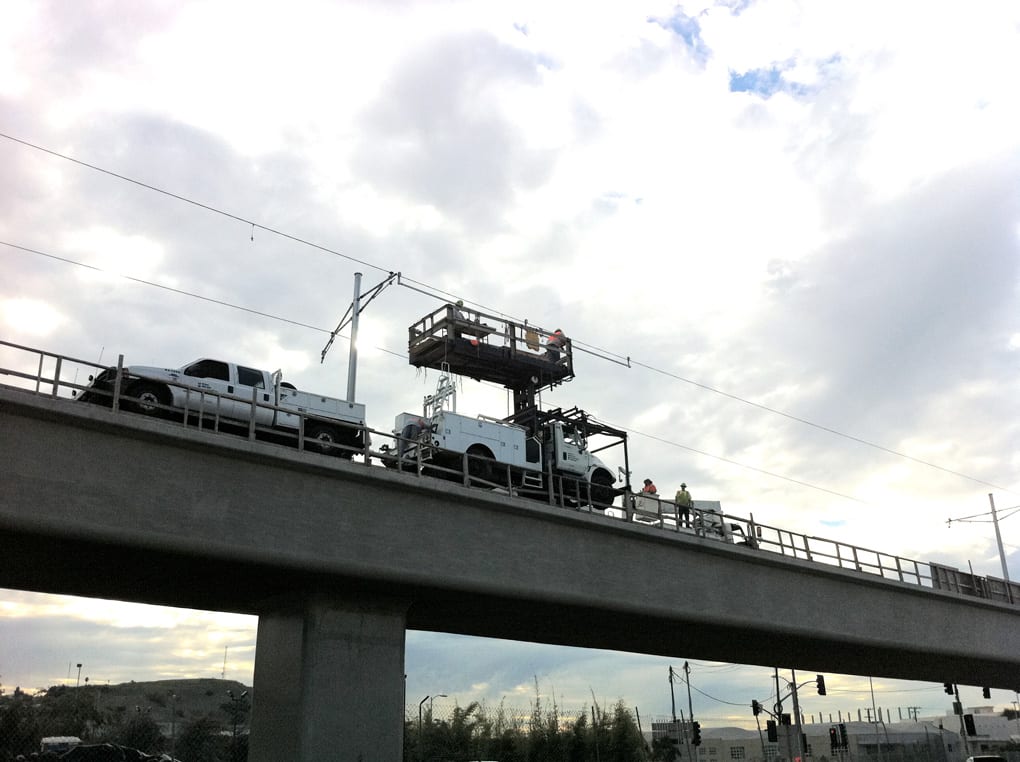 Workers install the catenary system over Ballona Creek.