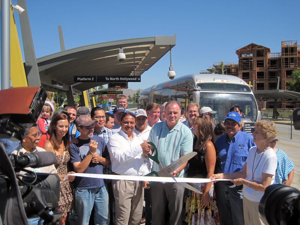 Canoga Station Metro Orange Line extension to Chatsworth construction chief Hitesh Patel, center, and John Parker, chairman of United Chambers of Commerce, join the Canoga Park/West Hills Chamber of Commerce for the ribbon-cutting at Canoga Station as the community welcomes the new four-mile extension of the Metro Orange Line. Photo by Dave Sotero.