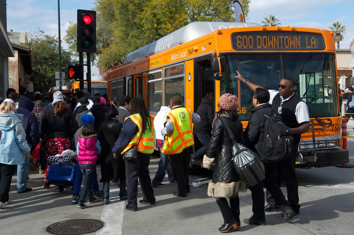 Metro buses await exiting parade crowd.