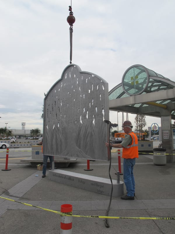 Workers set the sculpture into its base