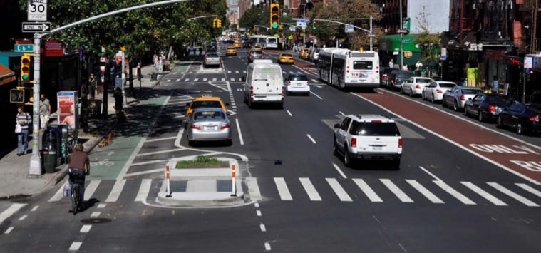 1st Street in New York after a makeover. A bus lane at right was added and at left, the parking lane was moved away from the sidewalk as a way to protect a new bike lane from the general traffic lanes. Photo: New York City DOT.