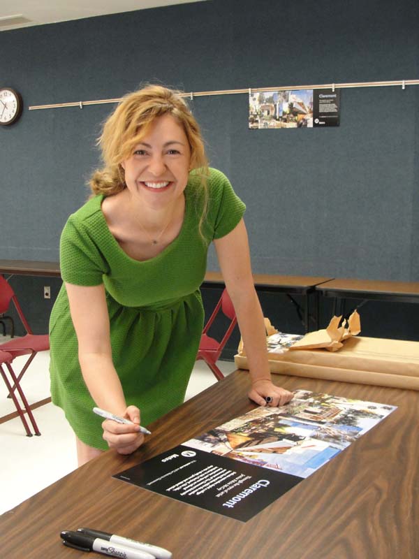 Artist Jessica Polzin McCoy signs free copies of her poster celebrating the city of Claremont on May 31 at an event at the Claremont Public Library.
