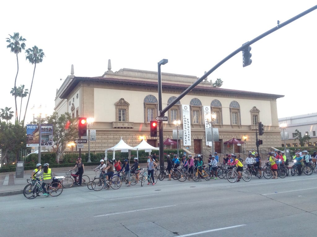Maria guides several dozen bicyclists in front of the Pasadena Civic Auditorium.