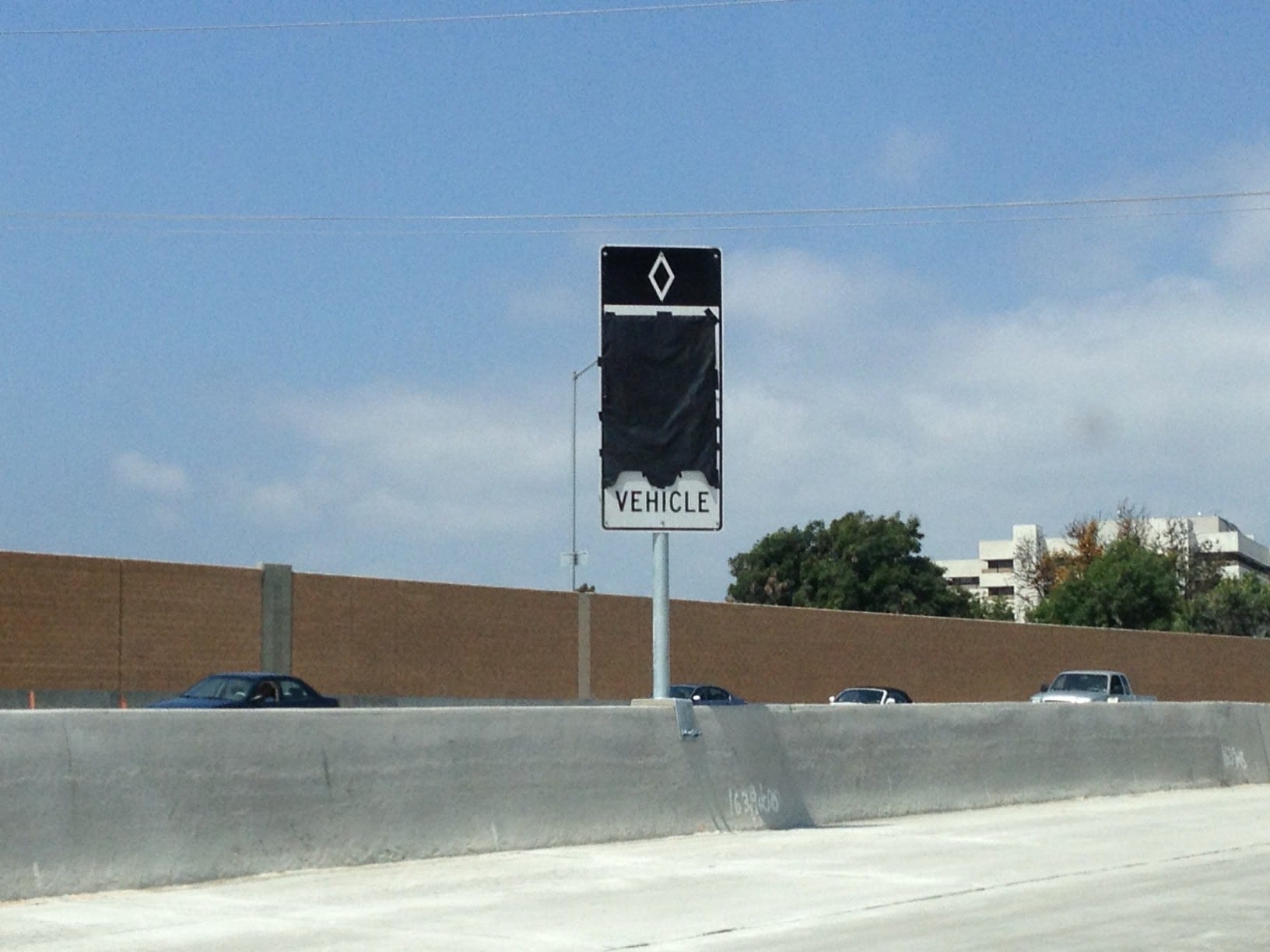 Contractor gets ready to open new carpool lane segment with installation of HOV signage at the freeway median.