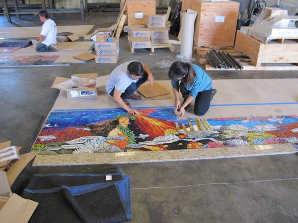 Metro Art Manager Angelene Campuzano, assisted by Metro Art Intern Janet Le, carefully inspect the artwork panels from the fabricator at the workshop in L.A. where they will be assembled into painted steel framed panels and readied for delivery to the station.