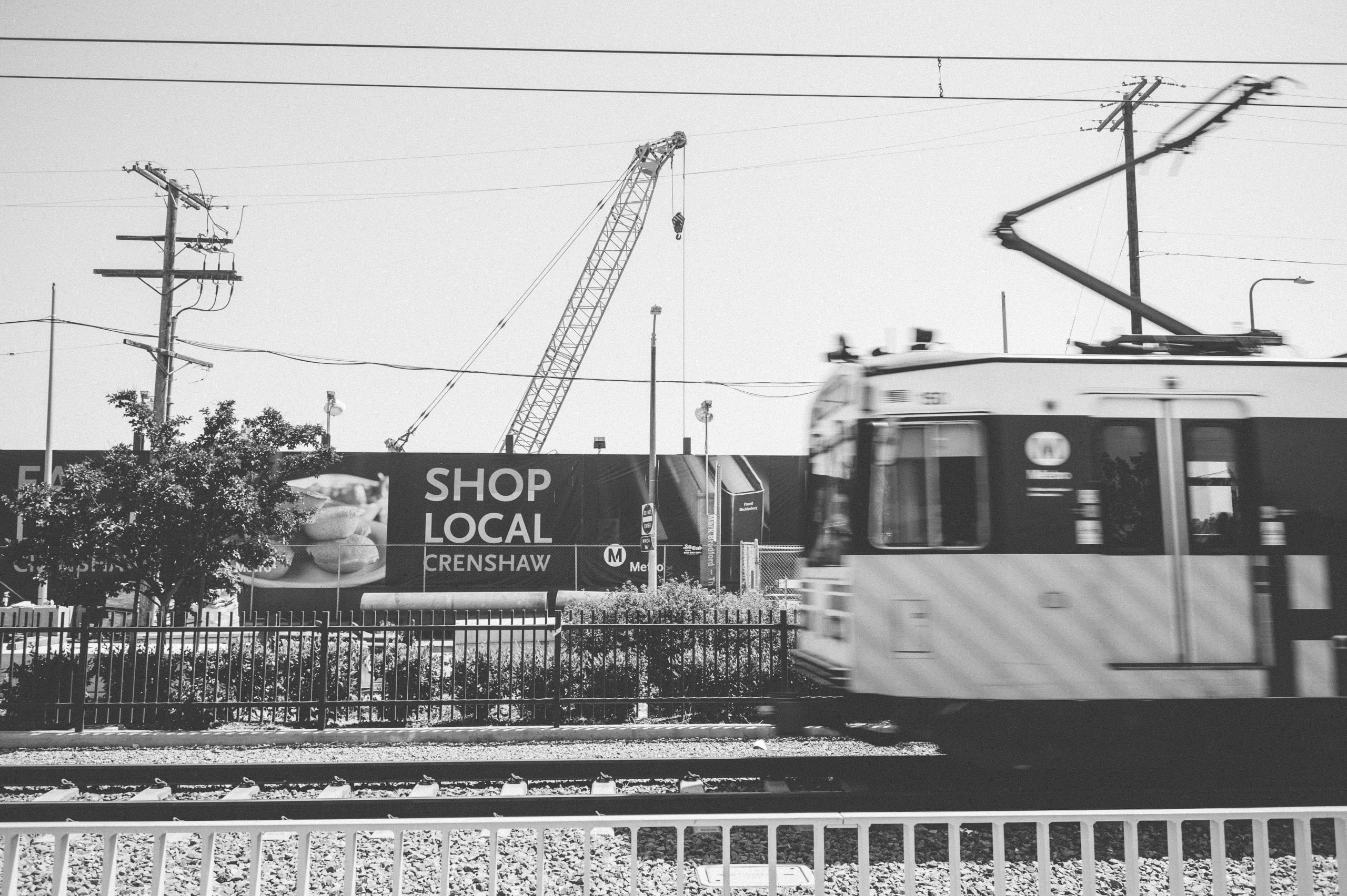 An Expo Line train passes the construction site for the Crenshaw/Expo Station for the Crenshaw/LAX Line.