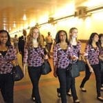 An entourage of officials and media follow Rose Queen's lead to the Gold Line station.