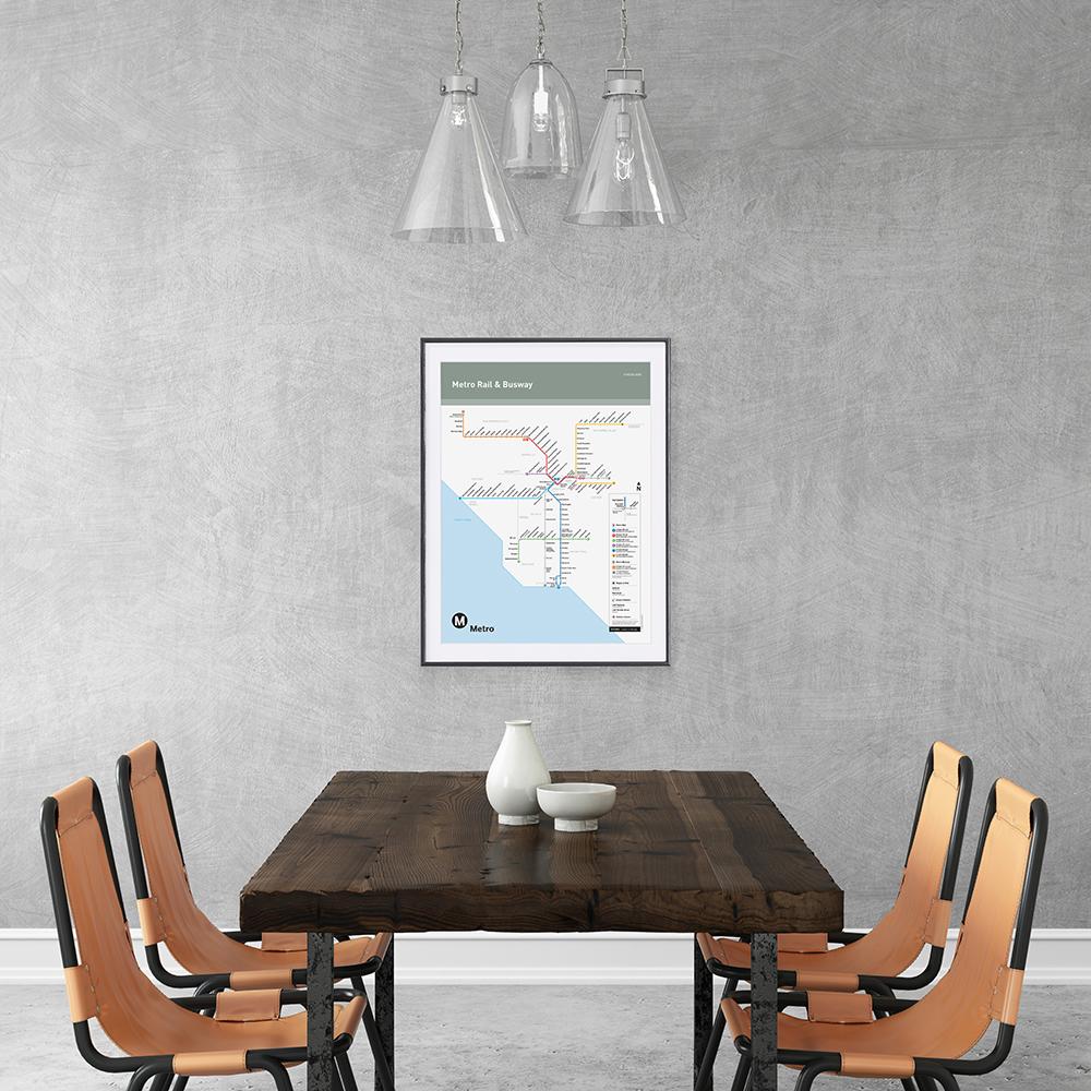 Blank interior wall template with dining table and chairs. Pendant light above. Gray concrete wall, chairs are orange hipster industrial. table made from wood. Go Metro rail map poster on the wall.