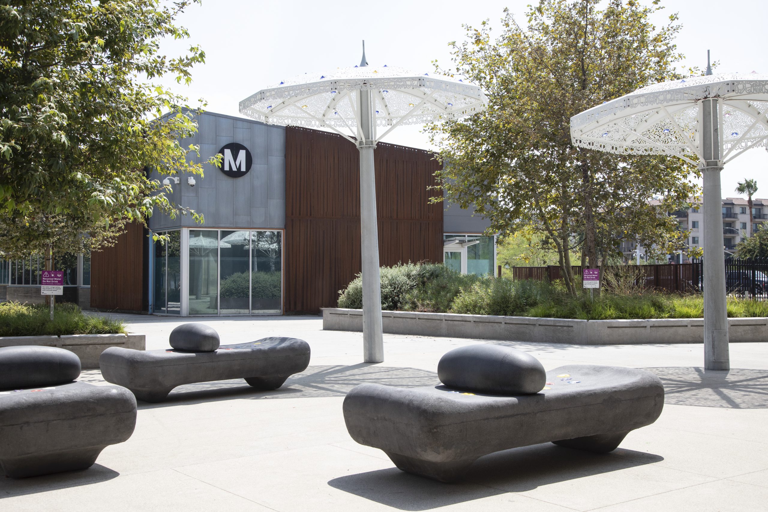 Glimpse of Judy Baca's benches and the "Second Line" parasol sculptures in front of the new Customer Center at the Willowbrooks/Rosa Parks transit hub.